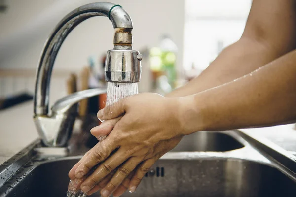 Always start with clean hands to prevent spreading of the coronavirus (Covid-19). Cropped shot of an asian man washing his hands at home