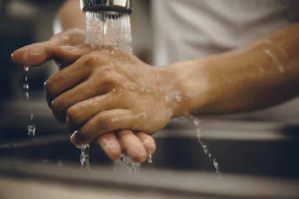 Always start with clean hands to prevent spreading of the coronavirus (Covid-19). Cropped shot of an asian man washing his hands at home