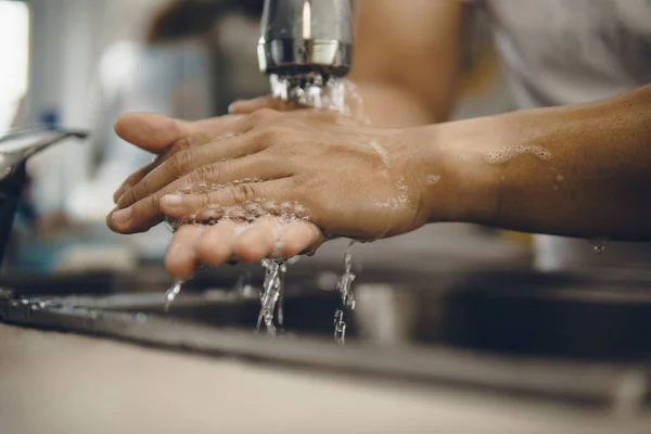 Always start with clean hands to prevent spreading of the coronavirus (Covid-19). Cropped shot of an asian man washing his hands at home