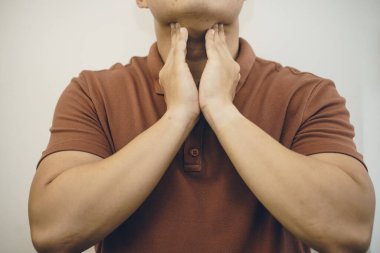 Genç Asyalı adam boğaz ağrısı çekiyor, 2019-nCoV ya da koronavirüs. Öğleden sonra 2.5 gibi hava yolu ile bulaşan solunum hastalıkları, kavga ve grip. Stüdyo çekimi beyaz arkaplanda izole edildi