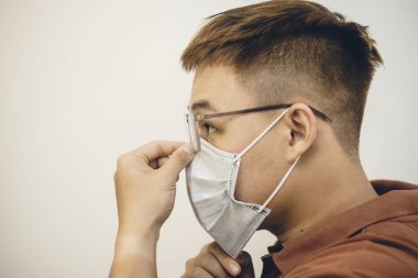 İş yerinde koronavirüse karşı koruma. Genç Asyalı adam hijyenik yüz maskesi takıyor. 2019-NCoV ya da Covid 19 salgını tarafından şok edildi. Stüdyo çekimi