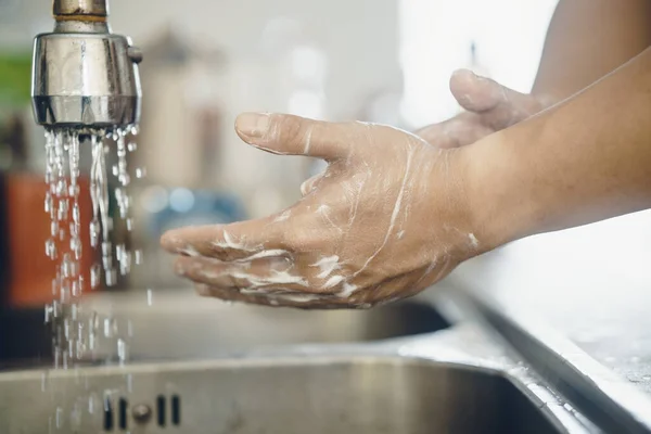 Always start with clean hands to prevent spreading of the coronavirus (Covid-19). Cropped shot of an asian man washing his hands at home