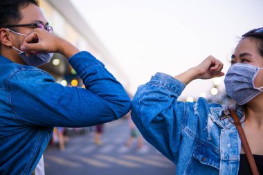 Coronavirus 'un (COVID-19) yayılmasını önlemek için yeni bir selamlama yöntemi. İki kişi (bir erkek ve bir kadın) sarılmak ya da tokalaşmak yerine dirseklerini birbirine vurur.