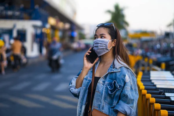 Mujer Joven Con Máscara Quirúrgica Calle Mientras Usa Teléfono Móvil — Foto de Stock