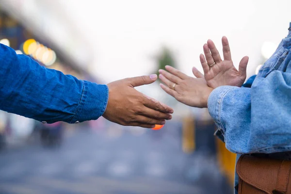 A new way of greeting to avoid the spread of coronavirus (COVID-19). Two people (a man and a woman) bump elbows instead of hug or handshake.