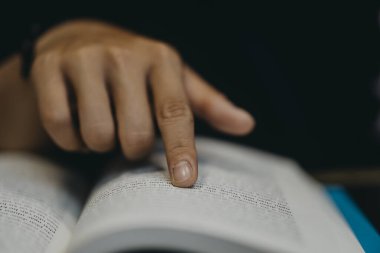Genç adam ameliyat maskesi takıyor ve Vietnam 'da bir kafede kitap okuyor.