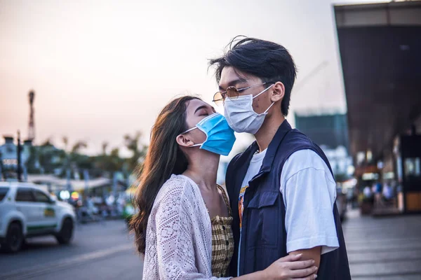 若いミレニアルカップル身に着けている保護顔マスクとキス ウイルス拡散防止と人々の概念 — ストック写真
