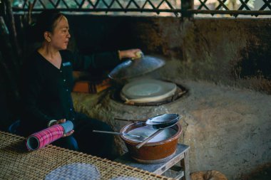 Cu Chi, Vietnam - 21 Aralık 2019 Cu Chi Tünel Müzesi 'nde pirinç kağıdı rulosu yapan Vietnamlı bir kadın.