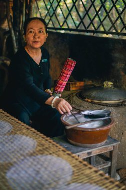 Cu Chi, Vietnam - 21 Aralık 2019 Cu Chi Tünel Müzesi 'nde pirinç kağıdı rulosu yapan Vietnamlı bir kadın.