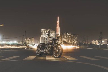 Ho Chi Minh city, Vietnam - March 25 2020: New Harley-Davidson Break Out 114 2020 is parked outdoor in Ho Chi Minh city. Powerful classic bike with black leather, grey and chrome details, Milwaukee-Eight large V2 engine. Landmark 81 and Bitexco tower clipart