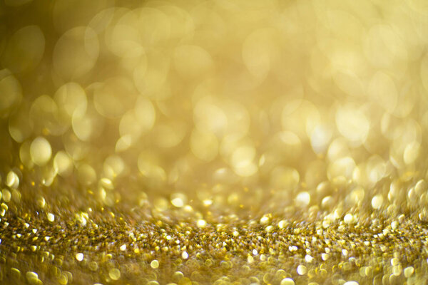 Абстрактный светлый и искрометный фон. Золотая и бриллиантовая пыль - размытое освещение от гладкой текстуры. Синий цвет Фон роскошного дизайна. Золотой праздничный глиттерный фон с боке золотыми огнями.
