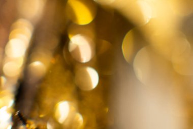 Bokeh 'in soyut altın arka planı. Arka planda tatil ışıkları. Bokeh odaklı ışıklar ve yıldızlarla şenlikli soyut arkaplan
