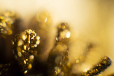 Bokeh 'in soyut altın arka planı. Arka planda tatil ışıkları. Bokeh odaklı ışıklar ve yıldızlarla şenlikli soyut arkaplan