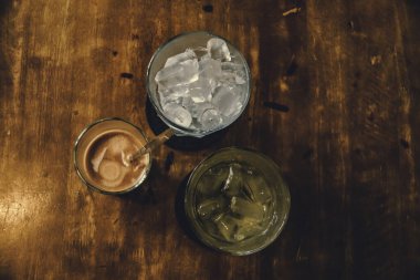 Tahta Masa üzerinde Vietnam sütlü kahve. Vietnam 'da geleneksel sıcak içecekler. Yakın plan Vietnam Drip kahvesi ve buzlu kahve, sütlü buzlu kahve..