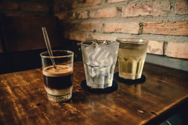 Tahta Masa üzerinde Vietnam sütlü kahve. Vietnam 'da geleneksel sıcak içecekler. Yakın plan Vietnam Drip kahvesi ve buzlu kahve, sütlü buzlu kahve..