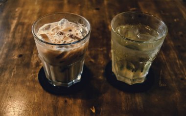 Tahta Masa üzerinde Vietnam sütlü kahve. Vietnam 'da geleneksel sıcak içecekler. Yakın plan Vietnam Drip kahvesi ve buzlu kahve, sütlü buzlu kahve..