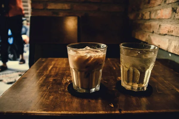 Vietnamese Milk Coffee on Wooden Table. Traditional Hot Drinks in Vietnam. Close-up Vietnamese Drip Coffee and Ice mug served with milk, Iced black coffee.