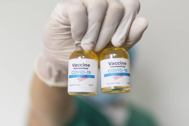 Doktorun elinde ilaç şişesi var, yakın plan. Aşı ve bağışıklık. Konsept: hastalıklar, tıbbi bakım, bilim, anestezi, ötenazi, diyabet, covid-19, coronavirüs