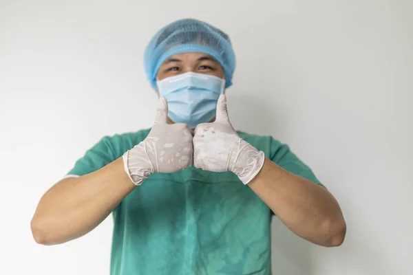 Thumbs up close up. Hands in rubber protective gloves. Shows like. Gesture as a symbol of approval of prevention and protect. Medical mask on the face. Positive man. Accepted and completed.