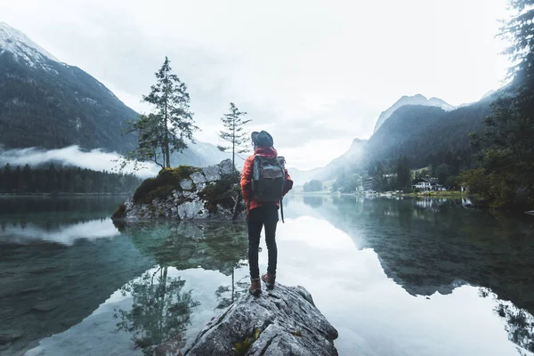 头戴礼帽背着背包徒步旅行的男人生活方式冒险的概念森林和湖畔野外度假的背景 — 图库照片