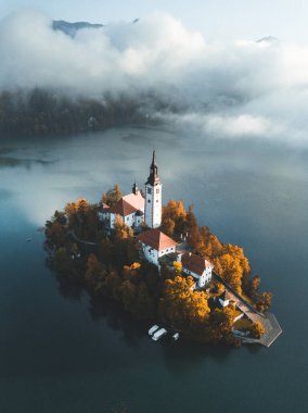 Julian Alpleri 'ndeki Triglav Milli Parkı' ndaki ünlü Bled Gölü Slovenya 'da sonbahar renklerinde bir ormanla