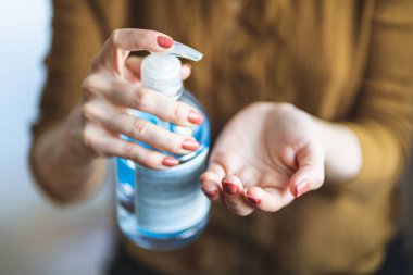 Close up female hands using wash hand sanitizer gel pump dispenser during coronavirus epidemic outbreak. Washing hand with hand sanitizer to avoid contaminating with Coronavirus. Disinfection concept clipart