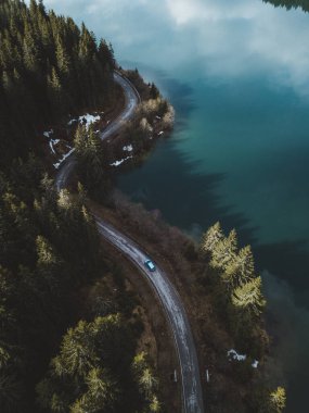 Yeşil çam ormanının havadan görünüşü ve gün batımında yukarıdan çekilmiş bir yol.