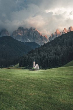 Scenic view of St. Johann (San Giovanni in Italian) chapel in Ranui /Val di Funes with the Dolomites Odle group on background. Beautiful sunset in South Tirol clipart
