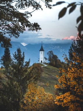 Jamnik Kilisesi St Primus ve Felician gün batımında, Slovenya. Tepe tarafında kiliseye giden yayan manzara, dramatik bulutlu gökyüzü, seyahat arka planı, ünlü turistik eğlence.