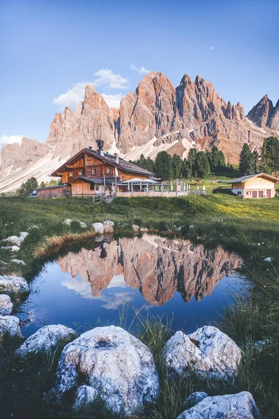 Yüksek tepeleri, ahşap kireçleri ve dağ gölü olan inanılmaz bir dağ manzarası. Ünlü Geisler - Gün batımında arka planda Odle zirveleri, Alto Adige, Dolomitler, İtalya, Avrupa
