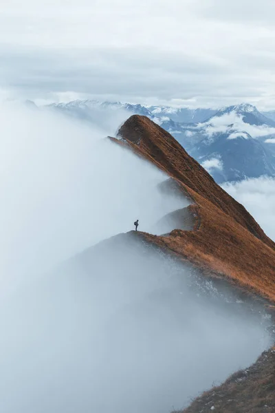 Hiker above valley. Man watch over misty and autumnal morning valley to moody cloudy weather. Tourist looking to misty valley bellow. Autumn cold weather while hiking Augstmatthor