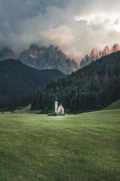 Arka planda Dolomites Odle grubunun bulunduğu Ranui / Val di Funes 'daki St. Johann (İtalyanca San Giovanni) şapelinin manzarası. Güney Tirol 'de güzel gün batımı