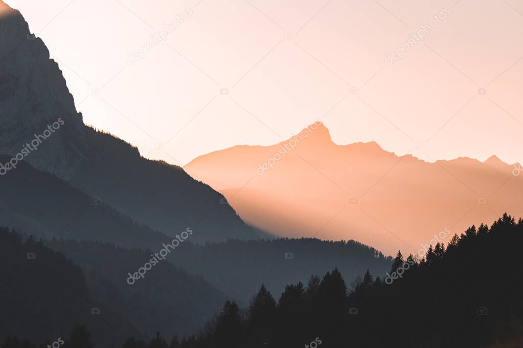 Orange and yellow sunset with mountains silhouettes. Gradient vivid nature background