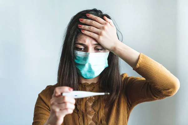 Mujer Joven Enferma Que Usa Una Máscara Quirúrgica Sostiene Termómetro — Foto de Stock