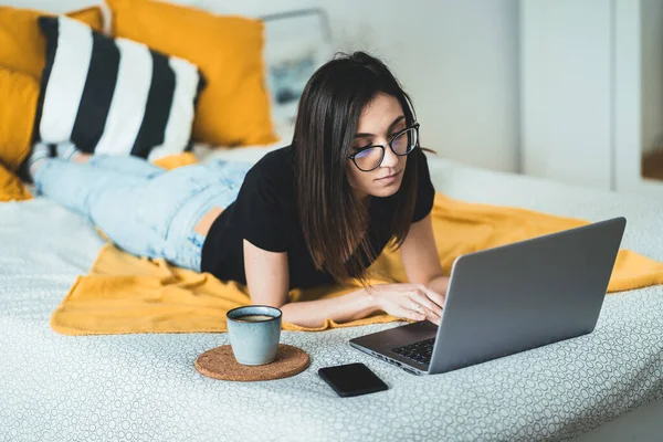 Yatakta gülümseyen çekici bir kadın evde bilgisayarla iletişim kuruyor, gözlük takıp bilgisayarda yazı yazıyor, internet alışverişinden hoşlanıyor ya da sosyal ağlarda sohbet ediyor.
