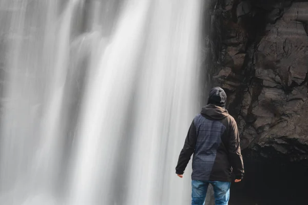 Человек смотрит на водопад — стоковое фото