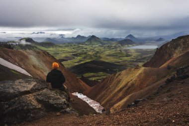 Hiker in yellow hat taking to admire landscape of Icelandic highlands August 2018