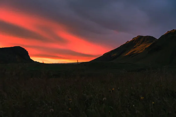 Belo pôr do sol cênico na Islândia. Lado da montanha iluminado amarelo com nuvens rosa . — Fotografia de Stock