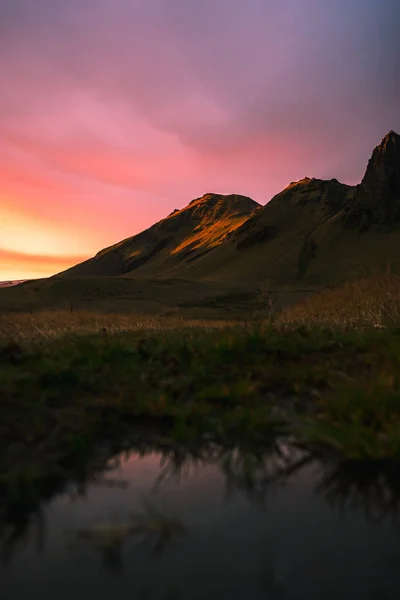 Hermosa puesta de sol panorámica en Islandia. Amarillo iluminado lado de la montaña con nubes rosadas.wate — Foto de Stock