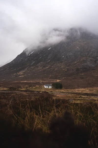 Μονόκλινο λευκό σπίτι δίπλα στο βουνό στα υψίπεδα της Σκωτίας — Φωτογραφία Αρχείου