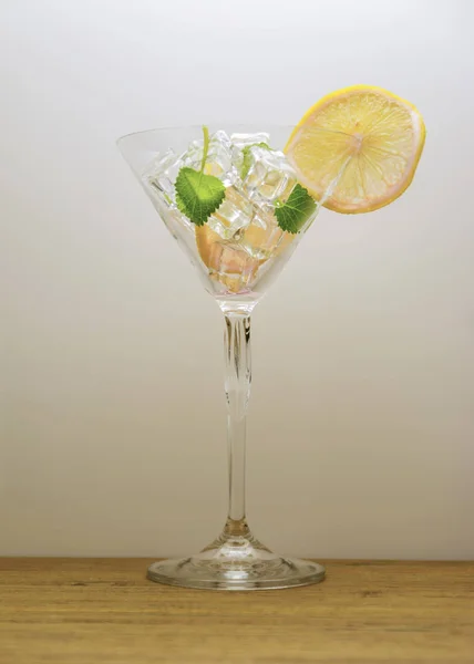 Bebida de coctel en la mesa, fondo blanco, cóctel con mesa de madera de hielo y limón, hoja de menta . —  Fotos de Stock