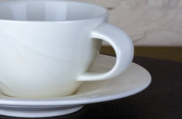 Stylowa biała filiżanka herbaty lub kawy na kamiennym stole i tle muru ceglanego. — Zdjęcie stockowe