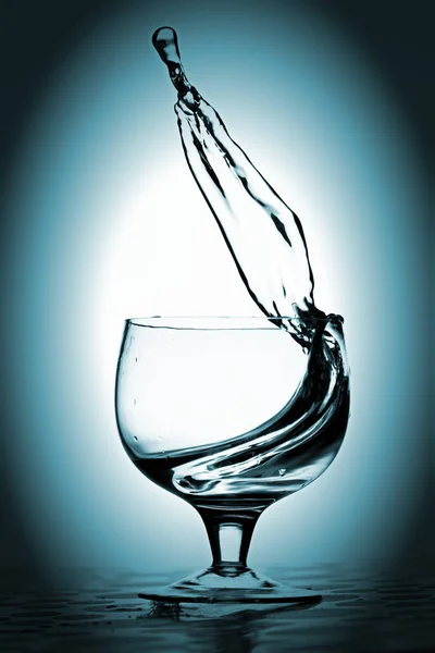 Πιτσίλισμα νερού στο ποτήρι, μπλε πράσινο φόντο. — Φωτογραφία Αρχείου