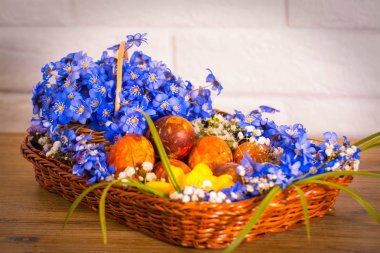 Fuar sepet kardelen Menekşe beyaz çiçek frezia ve Doğu ahşap masa ve beyaz tuğla arka plan üzerinde yumurta.