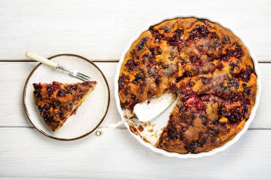 Beyaz tabakta taze kırmızı frenk üzümü turtası, beyaz ahşap masa arka planı. Pişmiş üzümlü turta.