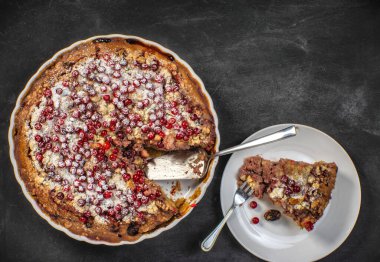 Beyaz tabakta taze kırmızı frenk üzümü turtası, beyaz ahşap masa arka planı. Pişmiş üzümlü turta.
