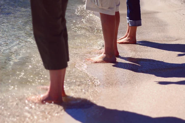 People standing on a beach in Door County, Wisconsin with their feet in the water