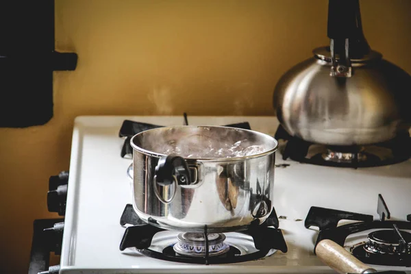 Brown eggs boiling in a small pot on the stove