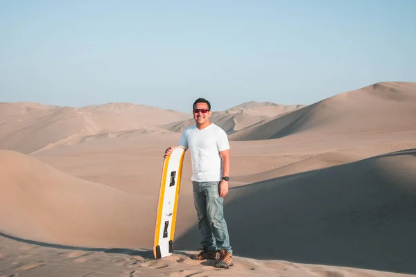 Man enjoying sand boarding at Huachina desert sand dunes Peru South America — Stock Photo, Image