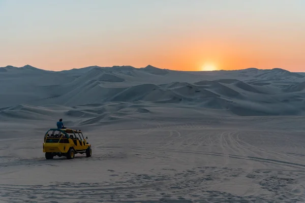 Hombre disfrutando de la vista de la puesta de sol en buggy duna Perú América del Sur —  Fotos de Stock